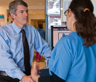 CTSI director, S. Claiborne Johnston, MD, PhD, speaks to a colleague at UCSF Med