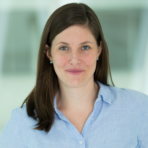 A white woman in a blue collared shirt.